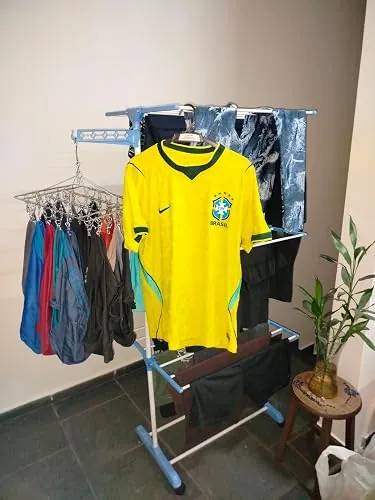 Varal Torre Cazaue em uso com roupas e camisa penduradas na casa de uma cliente